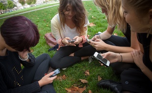 Des adolescentes utilisent leurs smartphones dans la ville de Bordeaux, en 2013. Illustration
