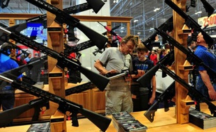 Un hommeet son fils observent un fusil d'assaut lors du congrès annuel de la la National Rifle Association (NRA), le 11 avril 2015 à Nashville, dans le Tennessee