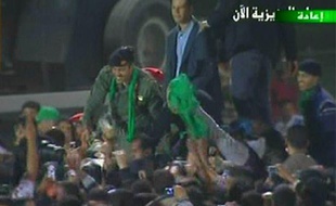 L'un des fils de Mouammar Kadhafi, Khamis (à gauche), salue la foule le 29 mars 2011 à Tripoli (Libye).
