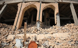 Un soldat irakien devant la tombe en ruines de Saddam Hussein.