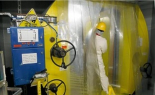 Maîtriser l'irradiation et la contamination du personnel est un défi quotidien que livre la centrale.La machine de serrage et de desserrage des goujons en action, avant l'opération de contrôle de la cuve du réacteur.