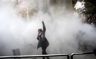 Un étudiant participe à une manifestation à l'université de Téhéran alors qu'une grenade fumigène est lancée par la police iranienne anti-émeute, samedi à Téhéran, en Iran. 30 décembre 2017. (AP Photo).