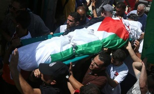 Des hommes portent le corps de Saad Dawabcheh, père du bébé palestinien brûlé vif, lors de ses funérailles à Douma en Territoires palestiniens, le 8 août 2015
