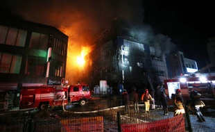 Des pompiers tentaient d'éteindre un incendie qui a démarré dans un immeuble de 8 étages