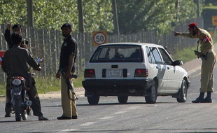 Des policiers et soldats pakistanais filtrent le trafic près d'Abbotabad, lieu où a été tué Ben Laden lors d'une opération américaine le 2 mai 2011 au Pakistan.