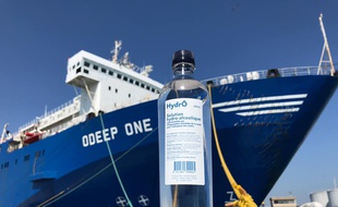 Une bouteille de solution hydroalcoolique devant le navire usine où elle a été fabriquée
