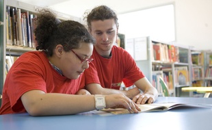 Une jeune fille prend un cours de soutien avec un étudiant bénévole de l'Afev.