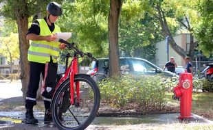 Un pompier de Rennes effectue une mission de vérification de poteau incendie avec un vélo électrique.