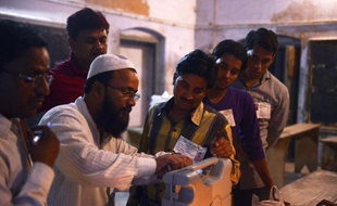 Des assesseurs mettent une machine à vote électronique sous scellés, à Varanasi (Inde), le 12 mai 2014