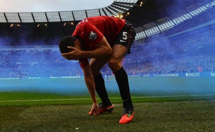 Rio Ferdinand, touché par une pièce de monnaie lors du derby entre Manchester United et Manchester City le 9 décembre 2012.