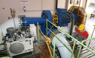 L'eau potable arrive par l'un des tuyaux bleu clair, entraîne la turbine bleu foncé, puis repart dans l'autre tuyau.