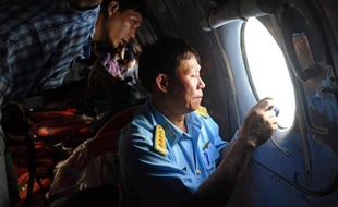 Un officier vietnamien effectue des repérages aériens pour trouver des traces du Boeing disparu de Malaysia Airlines le 9 mars 2014