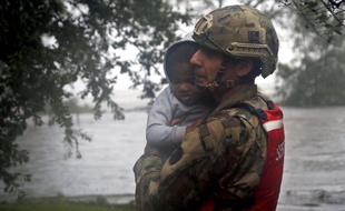 Un membre de la garde nationale porte secours à un enfant en Caroline du Nord, lors du passage de l'ouragan Florence, le 14 septembre 2018.