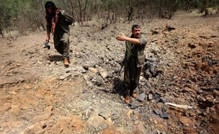 Des membres du PKK inspectent un cratère qui aurait été causé par un raid aérien turc le 29 juillet 2015 sur la montagne de Qandil, au nord de l'Irak