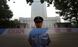 Un policier chinois se tient devant la cour populaire intermédiaire de Jinan, lieu du procès de l'homme politique déchu Bo Xilai, le 24 août 2013