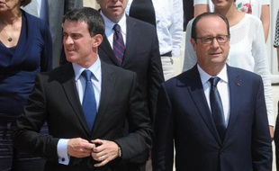 Le président François Hollande (d) et le Premier ministre Manuel Valls à la sortie d'un séminaire gouvernemental au Palais de l'Elysée à Paris, le 1er août 2014