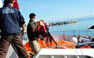 Des garde-côtes turcs portent le corps d'un enfant hors d'un bateau de secours le 8 février 2016 à Balikesir dans le district d'Altinoluk