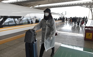 Des passagers débarquent à la gare de Wuhan, pour la première fois depuis deux mois, le 28 mars 2020.