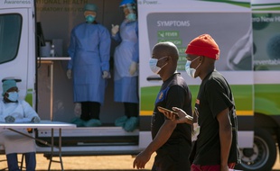 Des hommes devant une clinique de dépistage mobile du COVID-19 à Johannesbourg, en Afrique du Sud, le 21 avril.