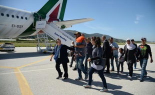 Un groupe de Syriens s'apprêtent à embarquer dans l'avion avec le pape François qui les ramène au Vatican le 16 avril 2016 à l'aéroport de Mytilène sur l'île de Lesbos