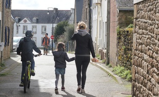 Une femme et ses deux enfants marchent dans une rue de Crac'h (Morbihan), commune touchée par le coronavirus où les écoles sont fermées.