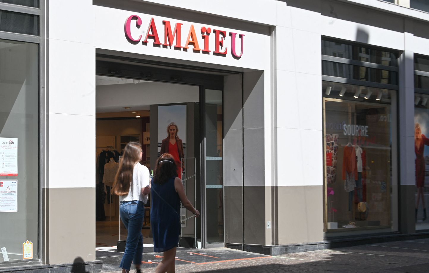 (FILES) In this file photo taken on May 27, 2020 people walk past a branch of the Camaieu brand in Lille, northern France. - A second hearing takes place on September 28, 2022 at the commercial court of Lille regarding Camaieu's receivership. (Photo by DENIS CHARLET / AFP)