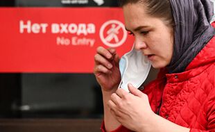 Une femme enlève son masque à la sortie du métro moscovite, le 13 octobre 2020.