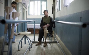 Les mains serrées sur des barres parallèles, Mounir Ahmad, un sergent afghan de 23 ans mutilé par une mine, apprend à marcher avec une prothèse dans un centre orthopédique, au nord de Kaboul. "L'armée ne faisait rien, dit-il. C'est ma famille qui m'a amené ici".