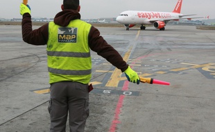 Illustration avion Easyjet a l'arrivee a l'aeroport Toulouse Blagnac. Logo manoeuvres dechargement des bagages.
Compagnie low cost Easy jet.