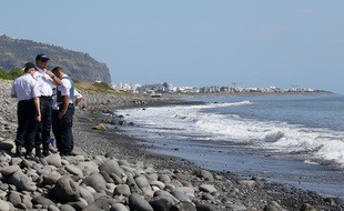 Des policiers français inspectent des débris métalliques trouvés sur une plage de la Réunion, le 2 août 2015.