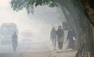 Des Indonésiens portent des masques contre la pollution de l'air à Pelmbang, au Sud Sumatra le 8 octobre 2015