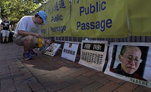 Un manifestant affiche des photos du Prix Nobel de la paix Liu Xiaobo et de son épouse Liu Xia, lors d'une manifestation à Hong Kong, le jeudi 13 juillet 2017