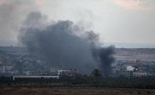 De la fumée s'élève de bâtiments touchés par une frappe aérienne israélienne dans la bande de Gaza le 17 juillet 2014