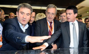 Le Premier ministre Manuel Valls (d) discute du projet de Grand Stade de rugby avec le maire de Ris-Orangis, Stéphane Raffalli (g) et celui d'Evry, Francis Chouat (c), le 4 décembre 2014 à Paris
