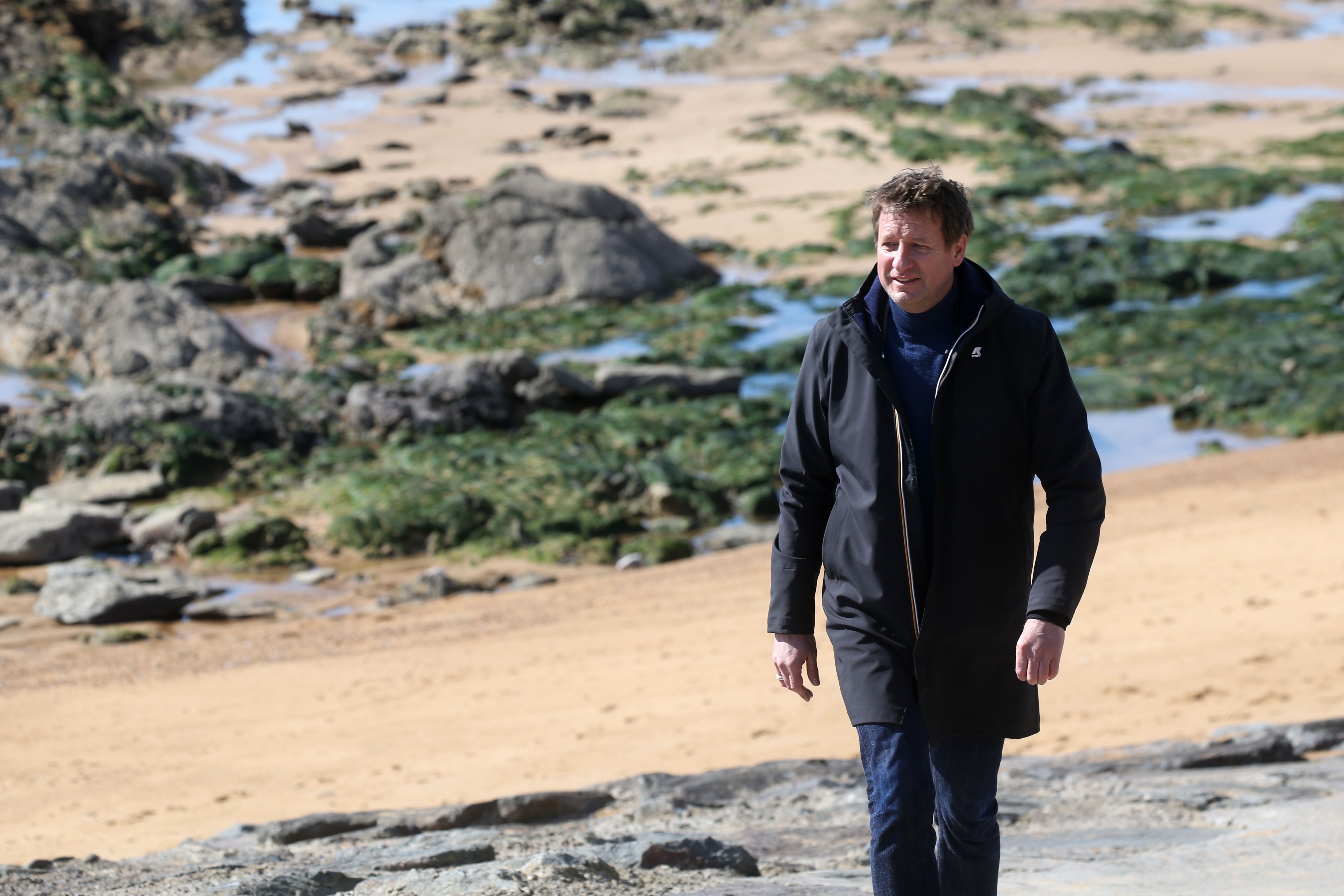 Yannick Jadot, seul sur le sable, les yeux dans l'eau.