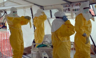 Des employés de Médecins sans Frontières (MSF) s'habillent le 18 octobre 2014 dans le centre de traitement de l'épidémie d'Ebola, à Monrovia