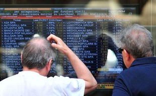Deux personnes lisent les résultats de la Bourse de Milan le 11 juillet 2011.