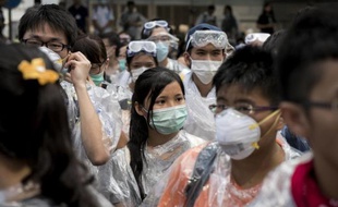Des manifestants, équipés de masques, lunettes et ponchos en plastique pour se protéger des gaz au poivre, rassemblés devant le siège du gouvernement, le 28 septembre 2014 à Hong Kong