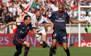 Les Parisiens Giuly (à g.) et Traoré (à dr.), autour du Lillois Vittek, lors d'un match de L1 le 30 août 2009 au Parc des Princes.