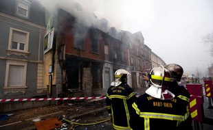 Les pompiers luttaient encore contre le feu qui a ravagé un immeuble d'habitation à Mulhouse, le 1er novembre 2011 au matin.