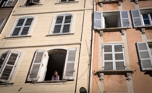 Une femme à la fenêtre d'un immeuble situé rue d'Aubagne à Marseille.