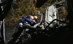 Photo fournie par le ministère de l'Intérieur des gendarmes inspectant les ruines du car accidenté, le 23 octobre 2015 à Puisseguin