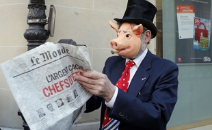 Un manifestant déguisé consulte le journal