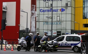 Des policiers devant le centre commercial Qwartz de Villeneuve-La-Garenne, dans les Hauts-de-Seine, le 13 juillet 2015
