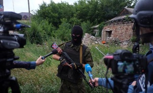 Un militant pro-russe masqué parle à la presse le 8 juillet 2014 à Donetsk, dans l'est de l'Ukraine, région où Amnesty a répertorié des centaines de cas d'enlèvements de torture