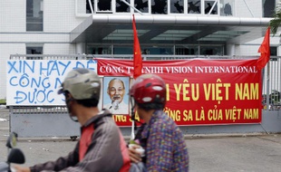 Deux hommes à moto passent devant une usine de la province de Binh Duong, au Vietnam, où les vitres ont été brisées par les manifestations anti-chinoises, le 15 mai 2014.
