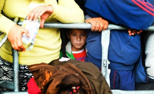 Un enfant attend avec d'autres migrants à la frontière austro-hongroise à Nickelsdorf (village autrichien) de monter dans un autobus, le 10 septembre 2015