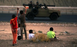 Des enfants yazidis saluent des combattants kurdes près de Dohuk, au Kurdistan irakien, le 12 août 2014