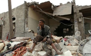 Un Yéméniste est assis devant des ruines devant sa maison familiale, endommagée par des frappes de la coalition saoudienne, dans la capitale Sanaa, le 13 juillet 2015