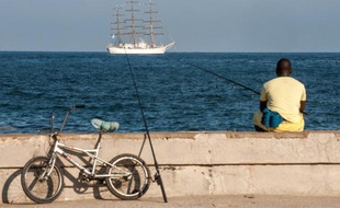 Un Cubain pêche dans le port de La Havane le 1er juillet 2014